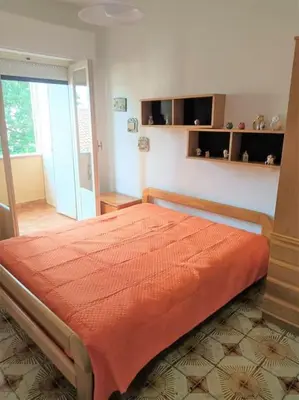 a bedroom with a bed with an orange bedspread at Mondello Ashur Margot House in Palermo