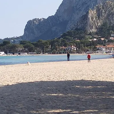 a group of people on a beach with a mountain at Mondello Ashur Margot House in Palermo