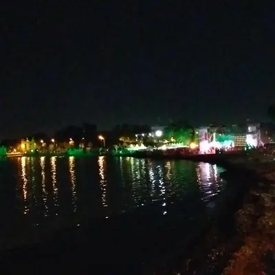 a city at night with lights on the water at Mondello Ashur Margot House in Palermo