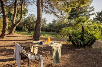 a table and chair with a table and drinks on it at Cleo - Villa Siciliana in Partinico
