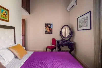 a bedroom with a bed and a mirror and a chair at Cleo - Villa Siciliana in Partinico