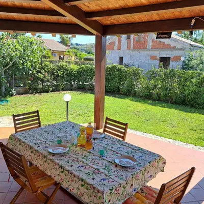 a table with plates and drinks on a patio at PTA Appartavilla in Campofelice di Roccella