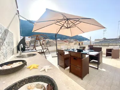 a patio with a table and an umbrella at Appartamento Alexa in Castellammare del Golfo