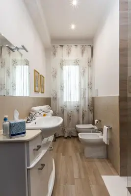 a bathroom with two sinks and a toilet at Gardenia Home in Palermo