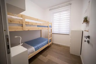 a small room with a bunk bed and a refrigerator at Matilde’s Holiday House in Terrasini