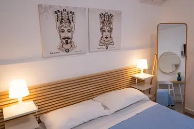 a bedroom with a bed with two lamps on it at Matilde’s Holiday House in Terrasini