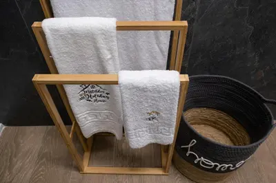 a towel rack with two towels and a basket at Matilde’s Holiday House in Terrasini