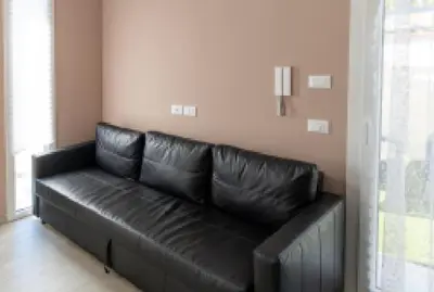 a black leather couch in the corner of a room at 3B Mondello Apartments in Palermo