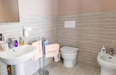 a bathroom with a white toilet and a sink at 3B Mondello Apartments in Palermo
