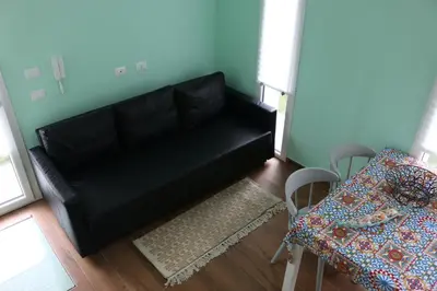 a black couch in a living room with a table at 3B Mondello Apartments in Palermo
