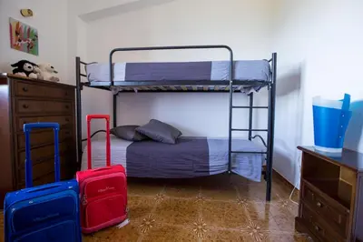 a bedroom with two bunk beds and two suitcases at Villa Duca Country House in Castellammare del Golfo