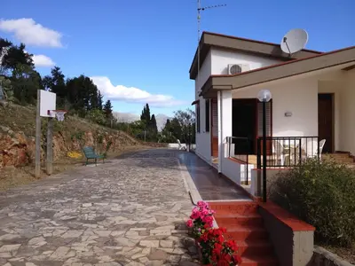 a house with a stone driveway next to a building at Villa Duca Country House in Castellammare del Golfo