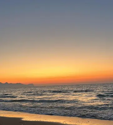 a sunset over the ocean with a sandy beach at Cusumano house in Trappeto