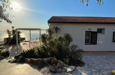 a house with a patio with a view of the ocean at Il Poggio Retreat - Cefalù in Cefalù