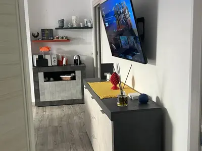 a living room with a counter and a tv on the wall at Casa Il Tramonto by Holiday World in Balestrate