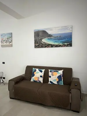 a brown couch in a living room with a painting on the wall at Appartamento Olivuzza House in Palermo