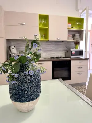 a vase with flowers on a counter in a kitchen at STABILE APARTMENT in Palermo