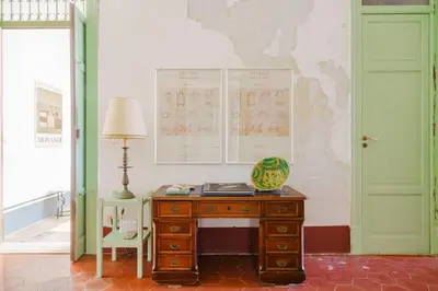 a desk with a lamp and a map on the wall at Tonnara Foderà di Magazzinazzi in Alcamo
