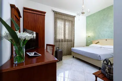a bedroom with a bed and a window at Araba Fenice Hotel in San Vito lo Capo