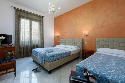 a bedroom with a bed and a window and a mirror at Araba Fenice Hotel in San Vito lo Capo