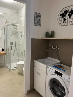 a bathroom with a washing machine and a shower at Matteotti35 in Terrasini