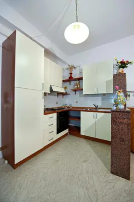 a kitchen with white cabinets and a white refrigerator at Casa Vacanze Spiaggia Playa in Castellammare del Golfo