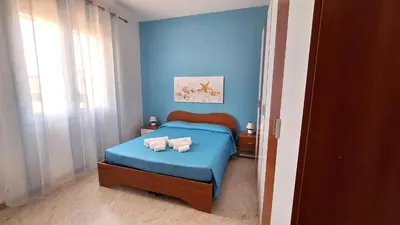 a blue bedroom with a bed with towels on it at Casa Vacanze Spiaggia Playa in Castellammare del Golfo