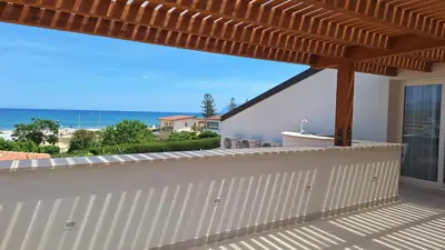 a balcony with a wooden pergola and the ocean at Casa Vacanze Spiaggia Playa in Castellammare del Golfo