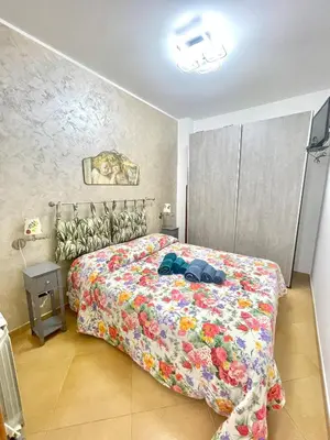 a bedroom with a bed with a colorful comforter at SinyHouse in Terrasini