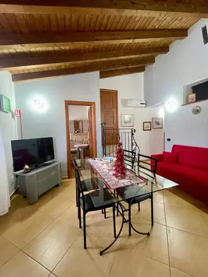 a living room with a table and a red couch at SinyHouse in Terrasini