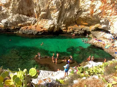 a group of people in the water at a beach at SinyHouse in Terrasini