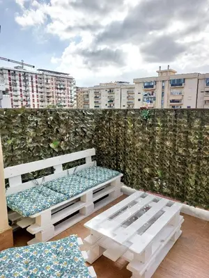a balcony with two benches and a wall with buildings at A casa di Mamma in Palermo