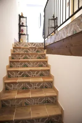 a staircase with wooden steps and a wrought iron railing at Baglio Buccellato in Scopello
