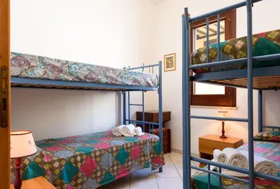 a bedroom with two bunk beds and a bed at Casa Karuscia in San Vito lo Capo