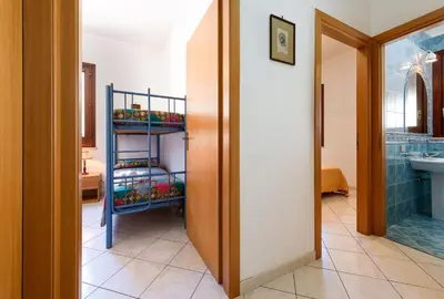 a bathroom with a sink and a shelf with towels at Casa Karuscia in San Vito lo Capo