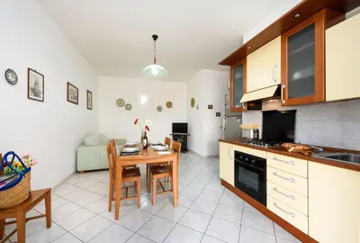 a kitchen and living room with a table and chairs at Casa Karuscia in San Vito lo Capo