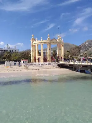 a bridge over a body of water with a building at La casetta di rosario mondello in Palermo