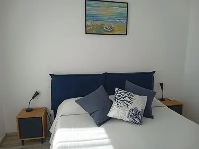 a bed with a blue headboard and pillows on it at La casetta di rosario mondello in Palermo