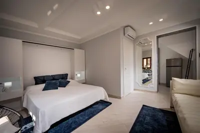 a bedroom with a white bed with blue pillows at La suite del Golfo in Castellammare del Golfo