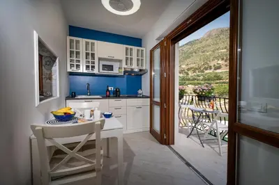 a kitchen with blue walls and a table and chairs at La suite del Golfo in Castellammare del Golfo