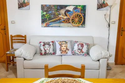 a living room with a couch and a painting on the wall at Casa Vacanze Villino Nando in Palermo