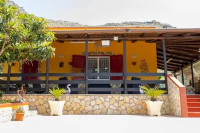 a yellow house with plants in front of it at Casa Vacanze Villino Nando in Palermo