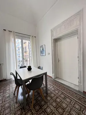 a dining room with a table and chairs and a window at Casetta Alice in Palermo