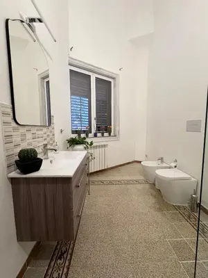 a bathroom with two sinks and a toilet and a mirror at Casetta Alice in Palermo