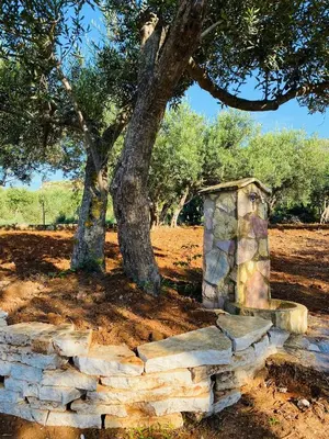 a stone wall in front of a tree at Villa L'orizzonte di calabianca in Castellammare del Golfo