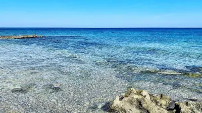 a beach with clear blue water and rocks at Casa Graziella Vacanze in Palermo