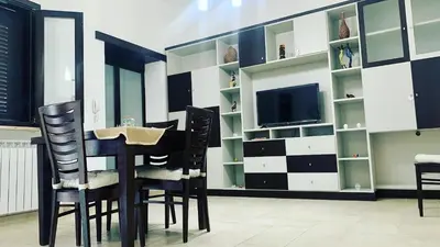 a dining room with black chairs and a tv at Casa Graziella Vacanze in Palermo