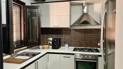 a kitchen with white cabinets and a stove top oven at Casa Graziella Vacanze in Palermo