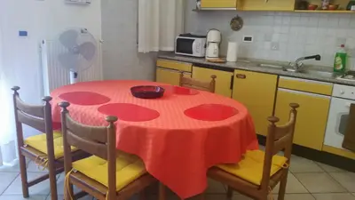 a kitchen with a table with a red table cloth on it at Terrasini Siracasa in Terrasini