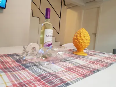 a table with a bottle of wine and a vase at appartamento politeama in Palermo